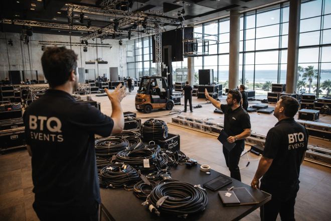 BTQ Events production crew during venue load-in with cabling and staging in progress